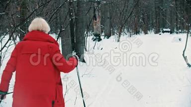一个身穿红色<strong>羽绒服</strong>的金发年轻女子在树林里滑雪